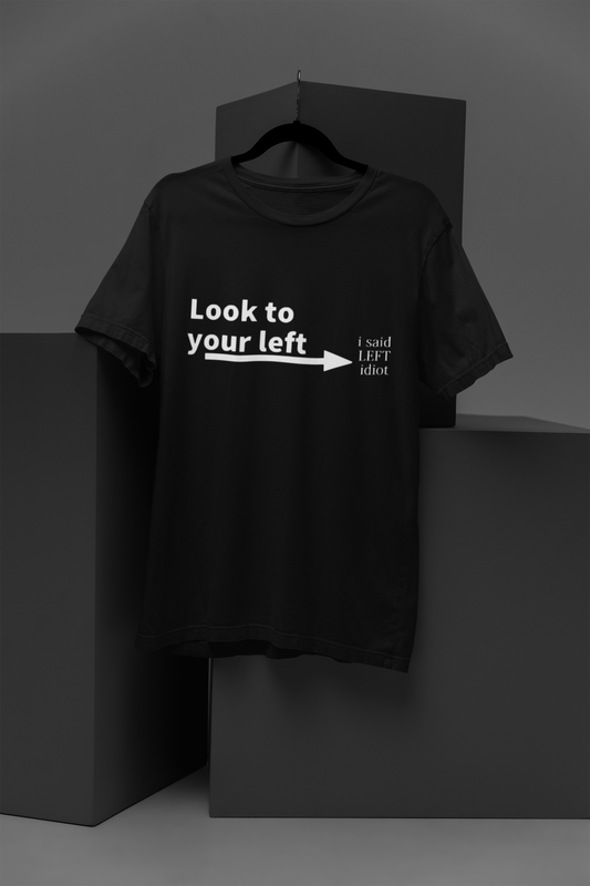 FOMO Fashions Idiot To Your Right T Shirt: black tee with humorous "Look to your left, idiot" text typography.